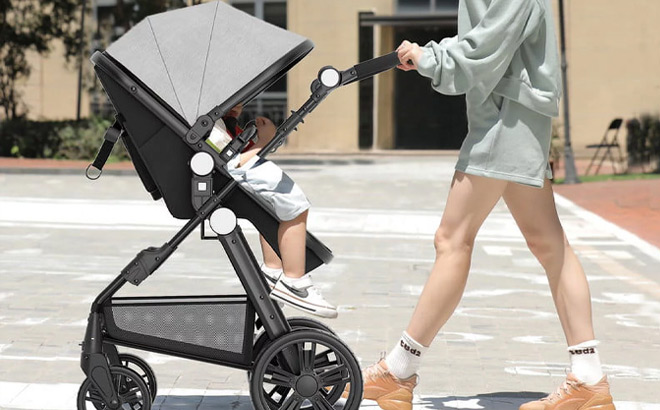 a Person Pushing Foldable Baby Newborn Stroller