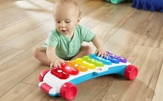 A Baby Playing with Fisher Price Giant Light Up Xylophone