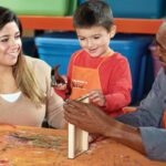 A Child holding a Hammer Creating a Blooming Picture Frame at Home Depot