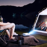 A Couple Watching a Band Performance Outdoor Using Elephas Mini Portable Projector