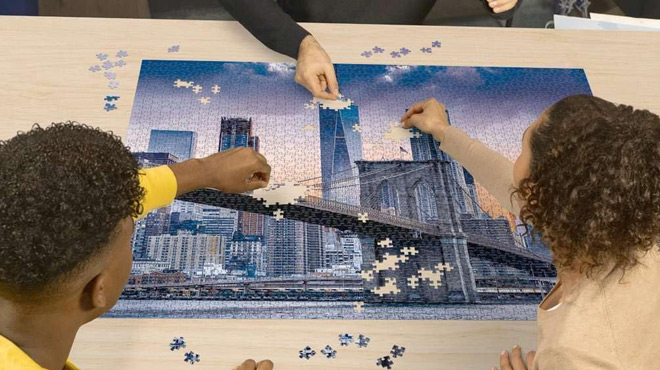 A Family Piecing a Ravensburger Skyline New York 2000 Piece Puzzle Together