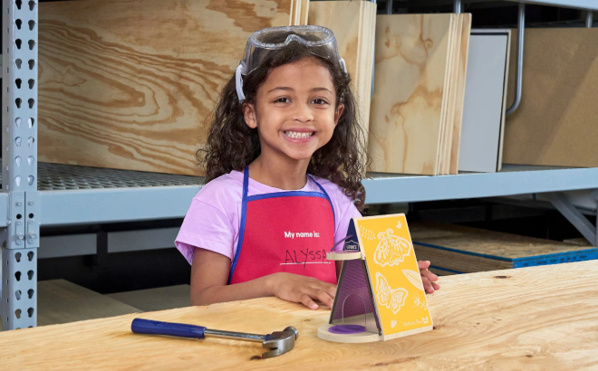 A Girl Holding a Butterfly Biome at Lowes Workshop