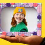 A Girl Holding a Frame Built from LEGO Bricks