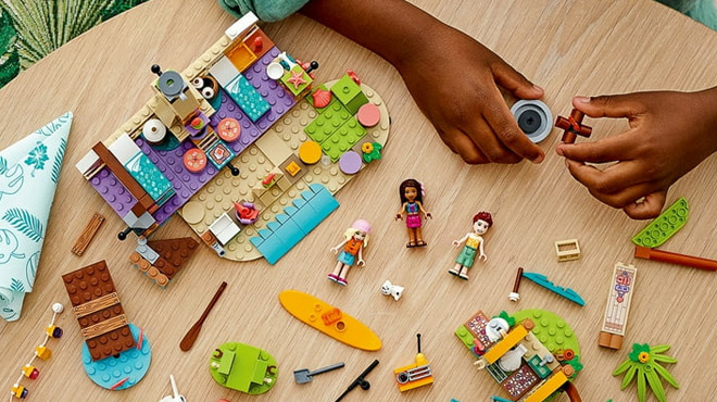 A Kid Playing with LEGO Friends Beach Glamping Building Kit