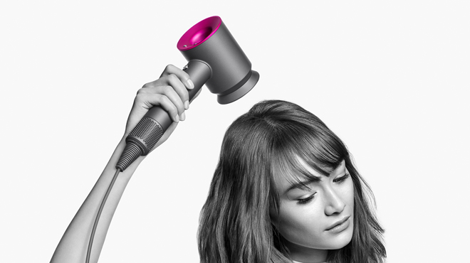 A Perosn Using a Dyson Supersonic Hair Dryer in Fuchsia