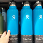A Person Grabbing a Hydro Flask Standard Mouth Water Bottle from a Store Shelf