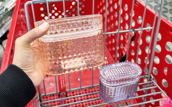 A Person Holding a Pink Glass Trinket Box with a Purple Glass Trinket Box in Cart