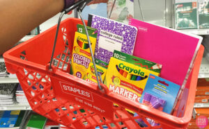 A Person Holding a Staples Basket with School Supplies