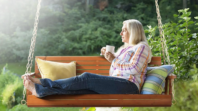 A Person Sitting on Patio Wooden Porch Swing
