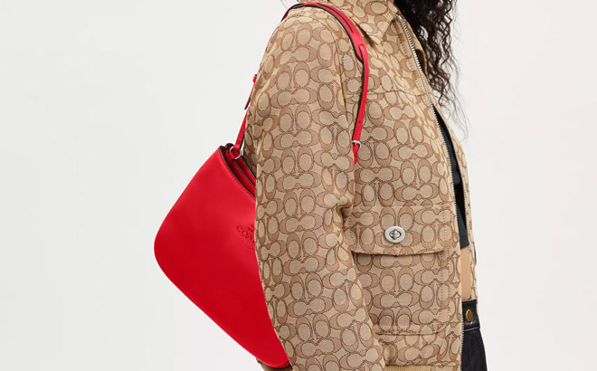 A Person Slinging a Coach Outlet Penelope Shoulder Bag In Bright Poppy Colors