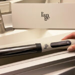 A Person Taking a Lange Hair Le Curl Titanium Curling Wand out of its Box