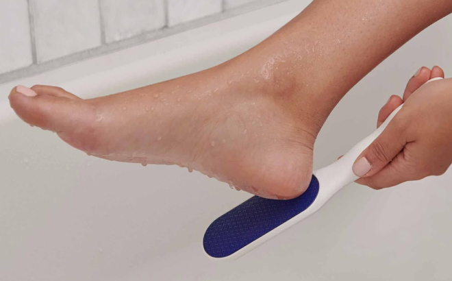 A Person Using Dr Scholls Nano Glass Foot File on Wet Foot