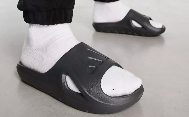 A Person Wearing Adidas Adicane Slide Sandal in Black Color