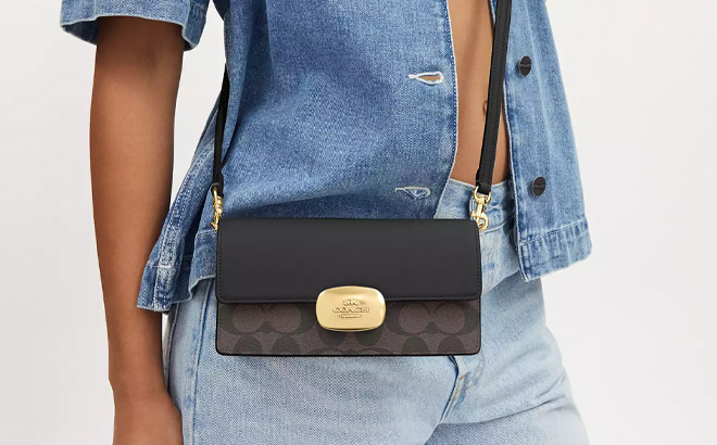 A Person Wearing Coach Outlet Eliza Small Flap Crossbody In Signature Canvas
