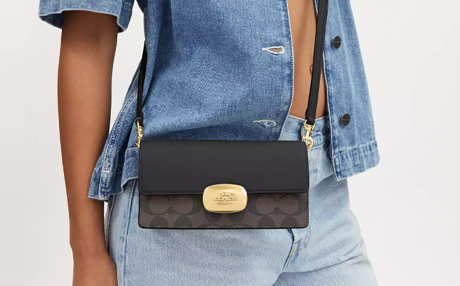 A Person Wearing Coach Outlet Eliza Small Flap Crossbody In Signature Canvas A Person Wearing Coach Outlet Eliza Small Flap Crossbody In Signature Canvas