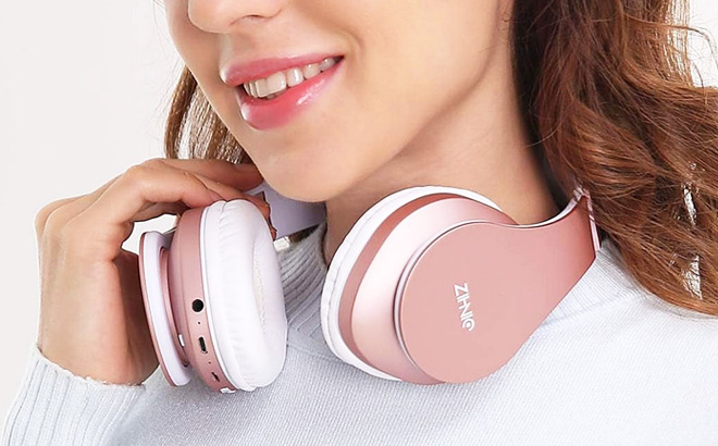 A Person With Zihnic Foldable Bluetooth Headphones in Rose Gold Color