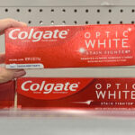 A Woman Holding Colgate Optic White Stain Fighter Whitening Toothpaste