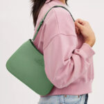 A Woman Wearing Coach Outlet Penelope Shoulder Bag in Soft Green