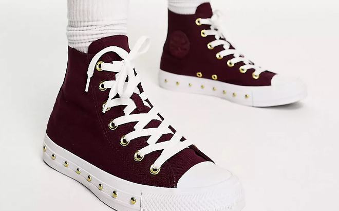 A Woman Wearing Converse Chuck Taylor All Star Studded Sneakers in Burgundy A Woman Wearing Converse Chuck Taylor All Star Studded Sneakers in Burgundy