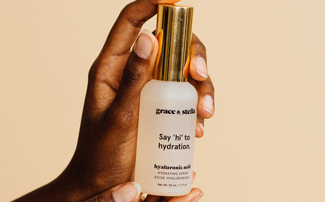 A hand holding Grace and Stella Hyaluronic Acid Serum