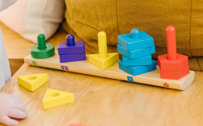 A kid playing with Melissa and Doug Stack and Sort Board