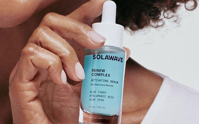 A lady holding Solawave Renew Complex Face and Neck Serum