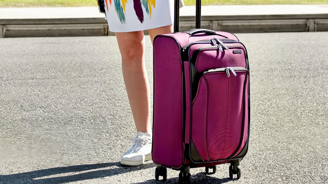 American Tourister Carry on Spinner Luggage next to a Person