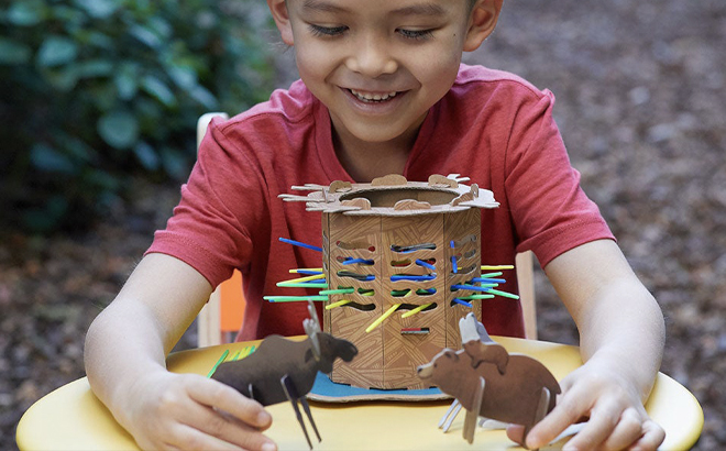 A Boy Playing With Two Animal Paper Toys