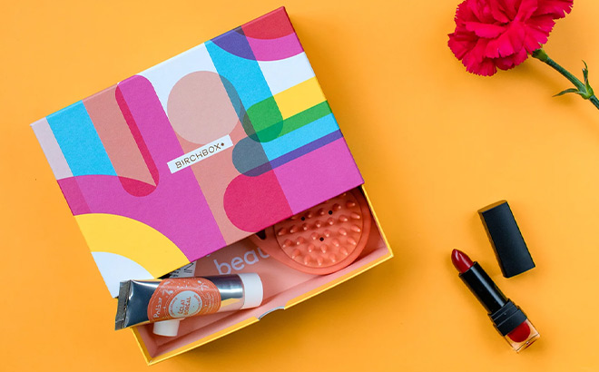 Opened Birchbox next to a Lipstick and a Flower