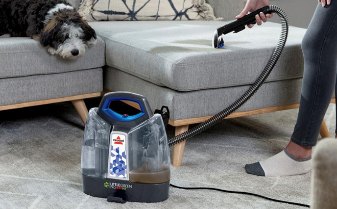 Person Cleaning with Bissell Portable Carpet Cleaner
