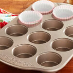 The Pioneer Women 12 cup Muffin Pan on a Kitchen Counter with Muffin Wrappers