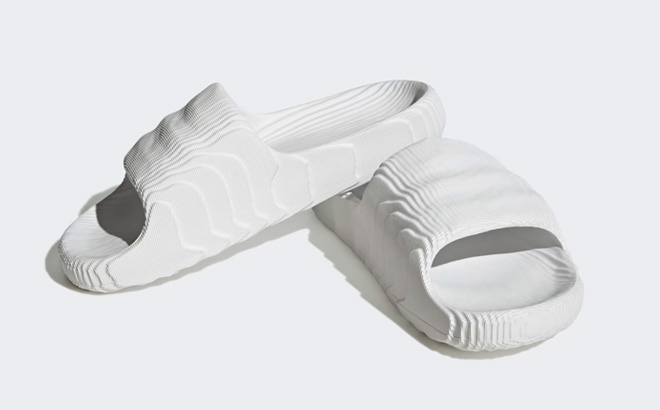 White Adidas Adilette 22 Slides on Gray Background White Adidas Adilette 22 Slides on Gray Background