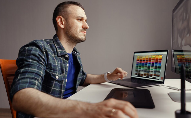 A Man Working on a Laptop and Computer