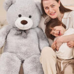 A Mother and Child Posing Beside a Giant 47 inch Teddy Bear Plush Toy