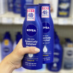 A Person Holding Two bottles of Nivea Essentially Enriched Body Lotion