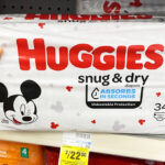 A Person Holding a Huggies Snug and Dry Diapers on CVS Shelf