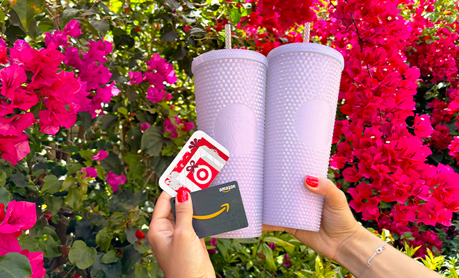 A Person Holding a Target and Amazon Gift Card with Two Lilac Starbucks Tumblers