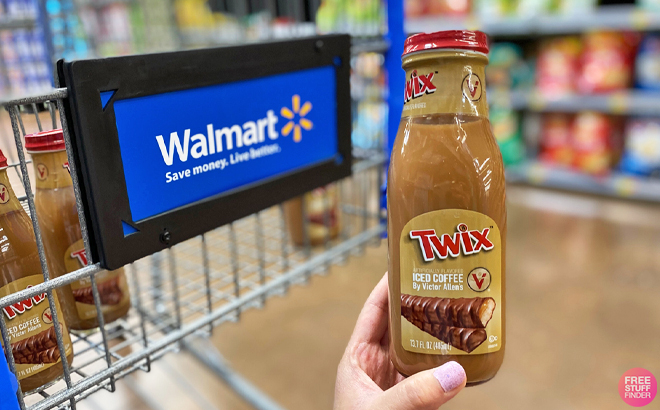 A Person Holding a Victor Allen Iced Coffee in Front of a Walmart Shopping Cart