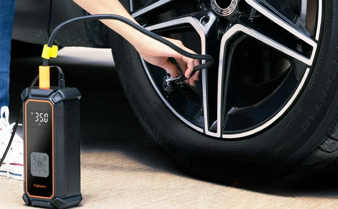 A Person Inflating His Cars Tire Using Ophanie DC 12V Tire Inflator A Person Inflating His Cars Tire Using Ophanie DC 12V Tire Inflator