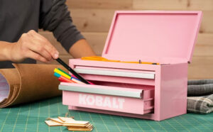 A Person Using a Kobalt Mini 2 Drawer Pink Steel Tool Box to Organize his Pens