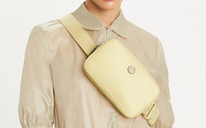 A Person Wearing Tory Burch Virginia Belt Bag in Lemon Sugar Color A Person Wearing Tory Burch Virginia Belt Bag in Lemon Sugar Color
