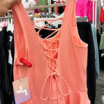 A Persong Holding and Showng the Back of the JoyLab Womens Knit Lace Up Detail Active Dress at Target