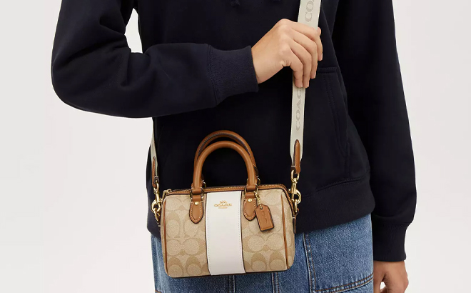 A Woman Wearing Coach Outlet Mini Rowan Crossbody In Signature Canvas With Stripe A Woman Wearing Coach Outlet Mini Rowan Crossbody In Signature Canvas With Stripe
