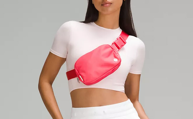 A Woman Wearing Lululemon Everywhere Belt Bag in Glaze Pink