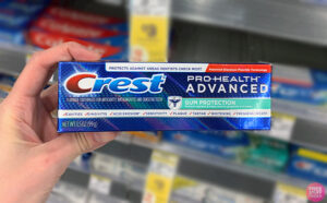 Hand holding one Crest Pro Health Gum Protection Toothpaste