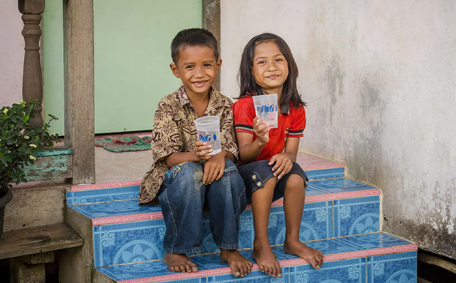 Two Kids Holding a Cup of Water