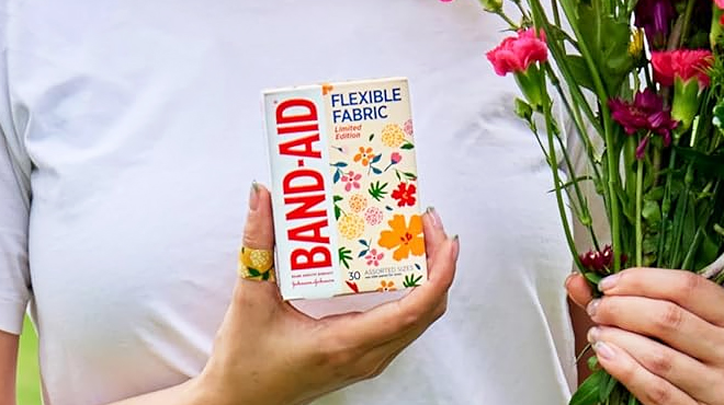 A Person Holding Band Aid 30 Count Flexible Fabric Bandages Wildflower