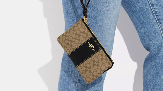 A Person Holding a Coach Outlet Corner Zip Wristlet In Signature Canvas A Person Holding a Coach Outlet Corner Zip Wristlet In Signature Canvas