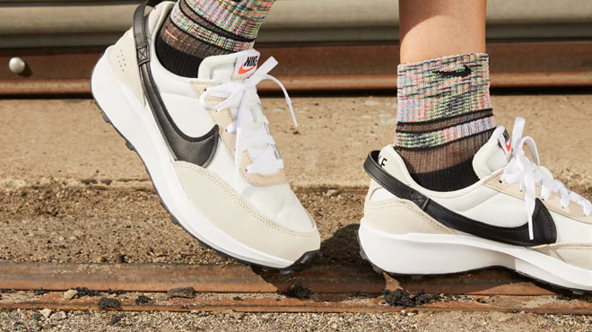 A Person Wearing a Nike Waffle Debut Womens Shoes in Sandrift Color