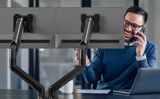 A Person Working Using a Dual Monitor PC with a Stand